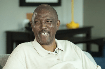 Dan, a Hep C and liver cancer patient, sitting in his living room and laughing as he shares how treatment has given him hope.