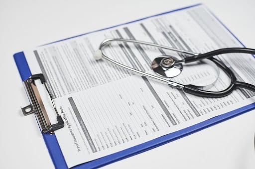 A stethoscope on top of a clipboard containing a paper with guidelines written on it